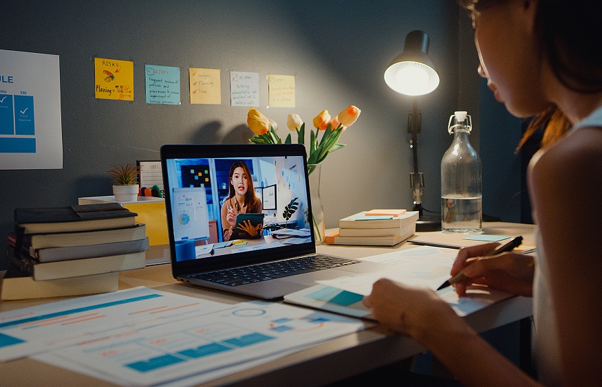 Asia businesswoman using laptop talk to colleagues about plan in video call meeting at living room at home.